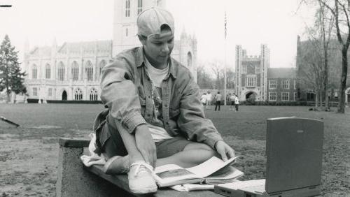 1995年，信誉最好的网投十大平台的学生拿着Power Book笔记本电脑在广场上.